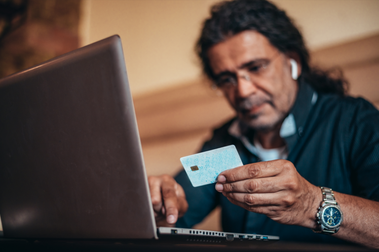 Senior hispanic cuban men using laptop to see how to prevent child identity theft and a credit card while online shopping